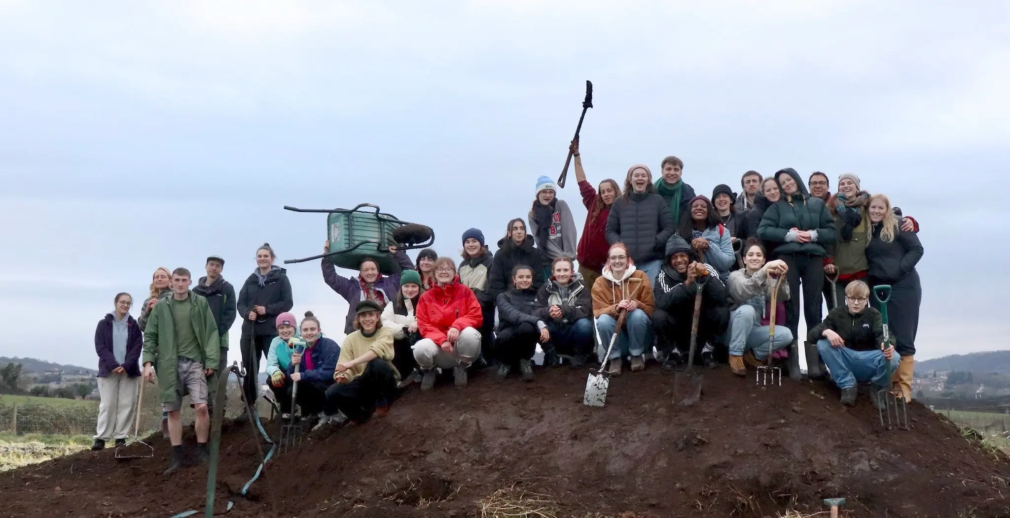 A group photo with us standing on heap of earth.