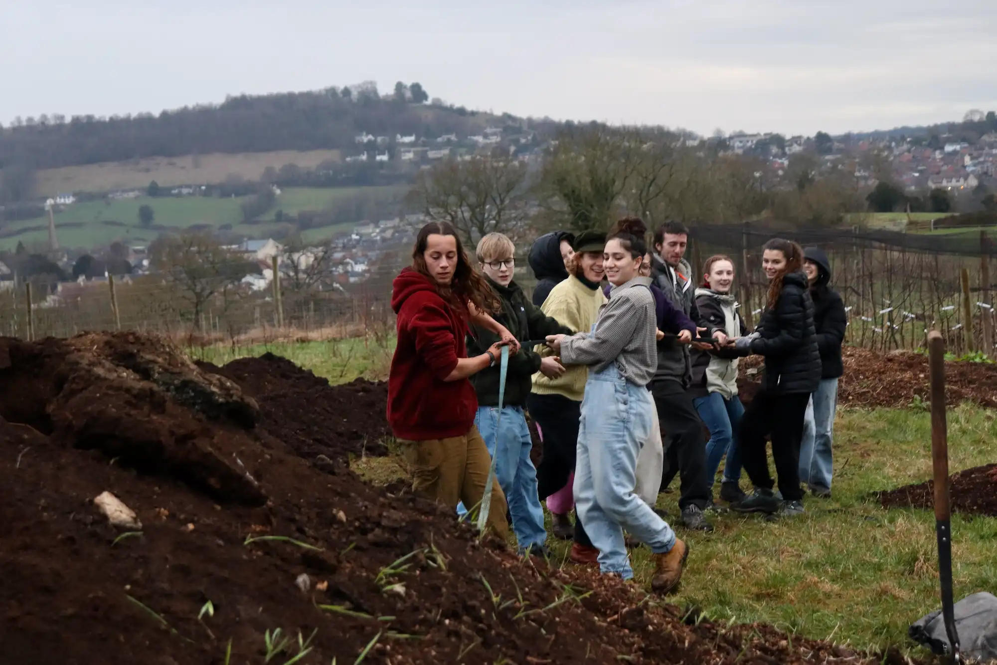 A group of us pulling a rope from a large pile of earth